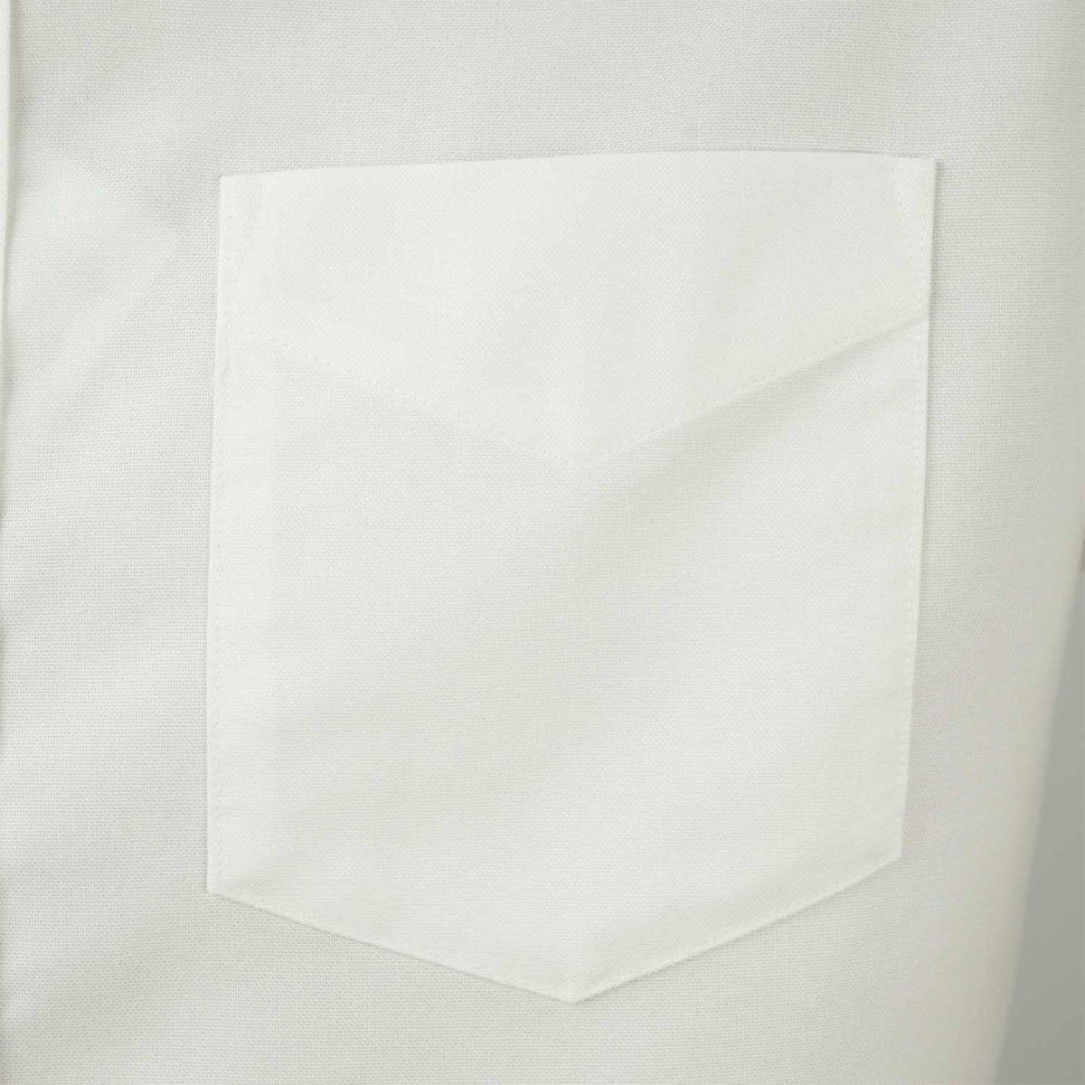 Close-up of white men's wrinkle-free oxford shirt pocket by Giordano with clean stitching details